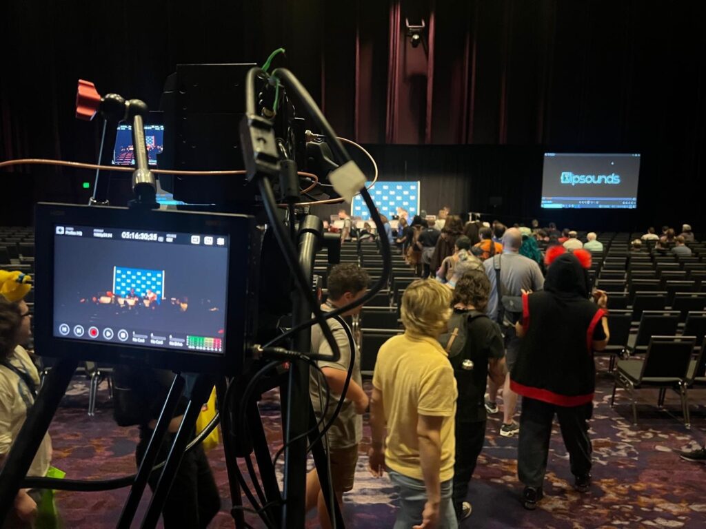 Live event recording in a theater with audio engineer staffing ensuring high-quality sound for the video feed.